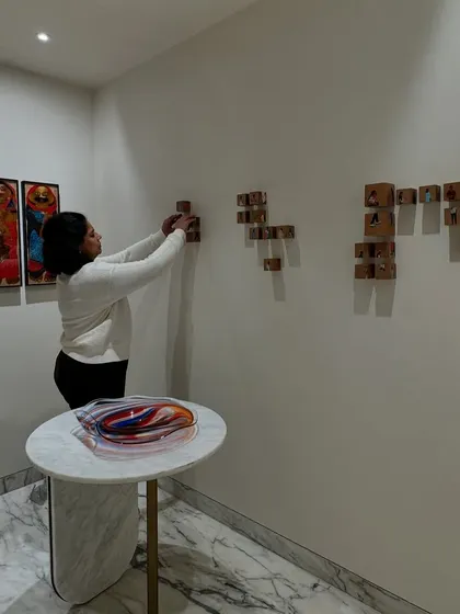 A member of our team carefully arranging an art installation. This image underscores the meticulous attention to detail that goes into the final styling of a home, ensuring every piece is perfectly placed.