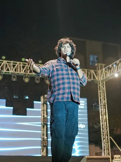 Joel D'souza interacting with the crowd in front of the branded 'Felicity' stage backdrop.