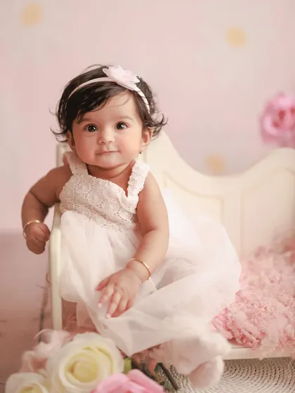 A precious portrait from a six-month milestone session. The soft pink tones and floral details create a delicate and dreamy setting for this little princess.