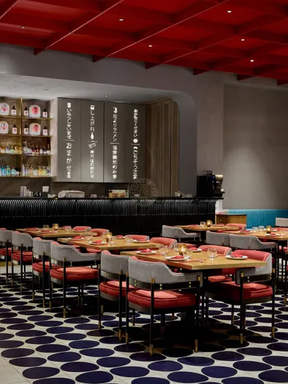 A view towards the bar at Foo, showing how the different elements like the patterned floor, teal booth, and modern chairs come together to create a cohesive and energetic vibe.