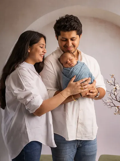 A shared moment of wonder. New parents gaze at their sleeping baby, a beautiful portrait of a family in awe of their new arrival.