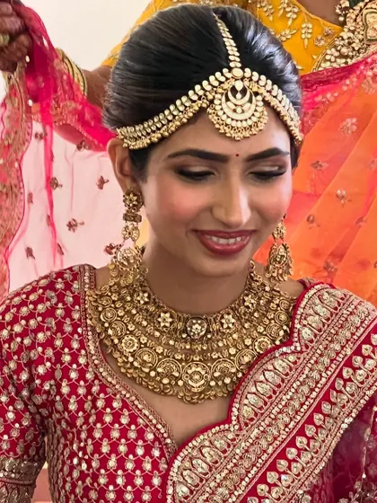 A beautiful bride ready for her wedding, her hair in a classic updo that perfectly supports her matha patti.