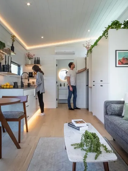 This image shows the open-plan living and kitchen area of a compact holiday home. The design focuses on maximizing space and light to create a comfortable and welcoming environment.