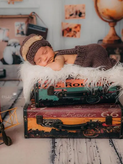 The complete travel-themed setup for this little explorer. With a globe, vintage camera, and tiny airplane, we created a whole world of adventure for his first portraits.
