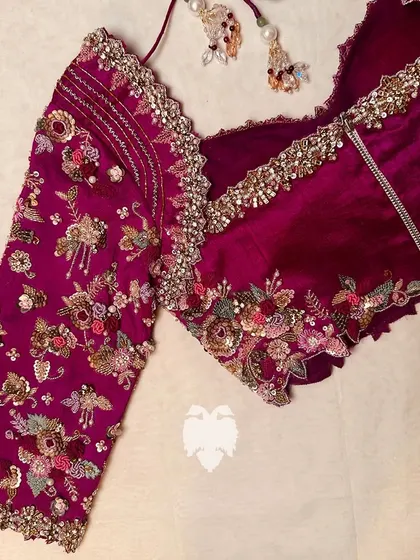 A dark pink raw silk corset blouse with intricate florals hand-embroidered with French knots and cutwork.