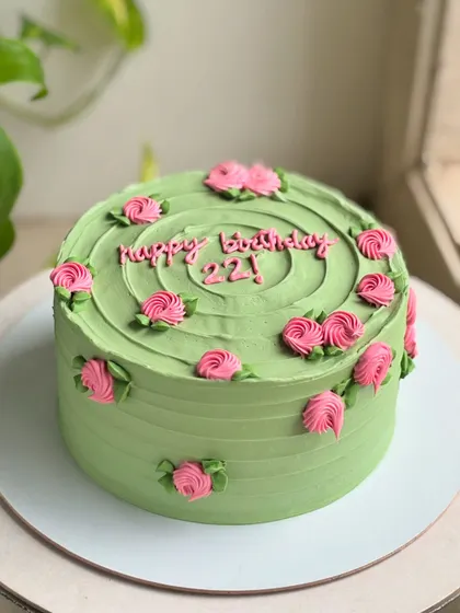 22 and blooming. This cake pairs a soft sage green buttercream with delicate pink rosettes for a timeless and fresh birthday design.