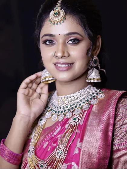 A close-up of a layered AD necklace set with green stone accents. This rental piece comes with a matching maang tikka and large jhumkas, providing a full set for a polished reception look.