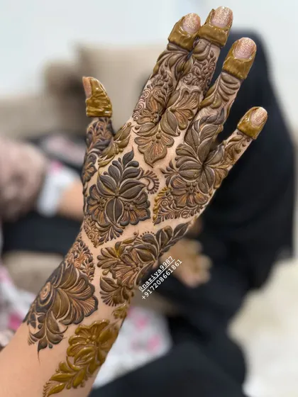 A close-up of a full-coverage floral design on the back of the hand. Every little space is filled with detail.