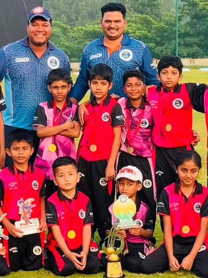 A group photo of a U-10 team with their coaches and trophies, celebrating a successful tournament.