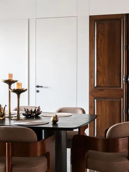 A detail shot showing the contrast between the antique wooden door and the clean, modern lines of the dining area. This juxtaposition of old and new is a signature element of our design philosophy.