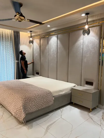 The combination of the upholstered wall, gold trim, and marble-patterned floor creates a truly luxurious feel.