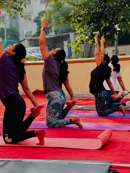 A moment of shared energy as our members practice a kneeling crescent pose together during our outdoor yoga event.
