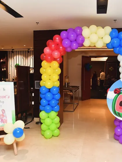 This Cocomelon-themed entrance is bright and inviting. A rainbow balloon arch is paired with a character cutout and a personalized welcome board to greet the party guests.