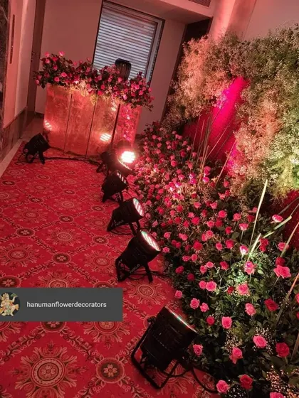 A closer look at a luxurious floral installation. Here you can see the detail of the red roses and baby's breath, with professional spotlights used to highlight the texture and color of the flowers.
