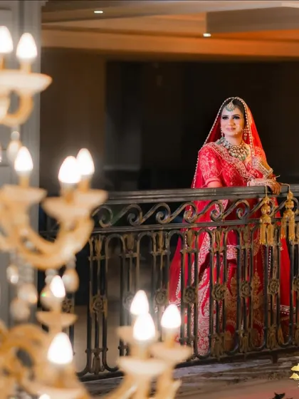 A grand bridal portrait on a balcony, with the chandelier adding a touch of luxury.