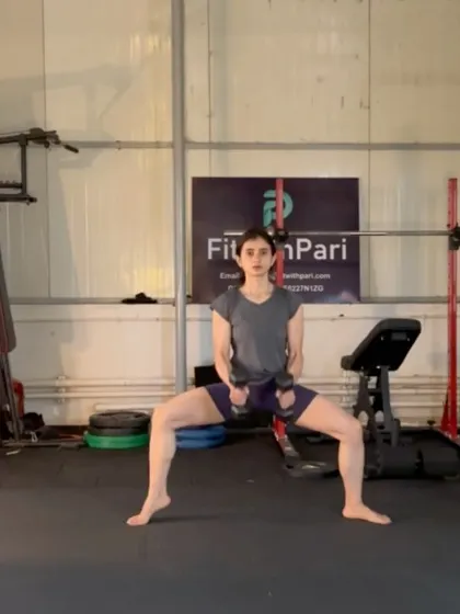 A plié squat hold with dumbbells. Isometric holds are a great way to build muscular endurance and mental toughness.