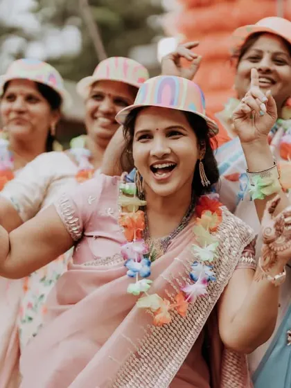 The bride's squad having a blast at a carnival-themed party, complete with fun hats and garlands.