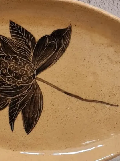 A close-up of my organic oval plate with a hand-painted lotus, showcasing the intricate sgraffito details. This multifunctional piece is perfect for serving or as a decorative accent.