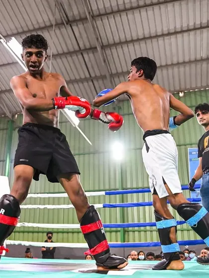 The intensity of a competitive kickboxing match is captured in this moment. Our black belt coach Vinod is seen here in a close-range exchange during the World Kickboxing Network tournament, showcasing the grit and technique we teach.