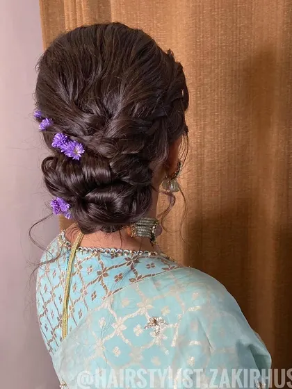 A soft, romantic updo with delicate purple flowers tucked in. This is a great option for a bridesmaid or for a daytime event.