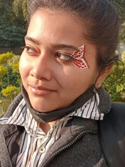 A small, red butterfly design that looks like a delicate accessory on the corner of the eye.