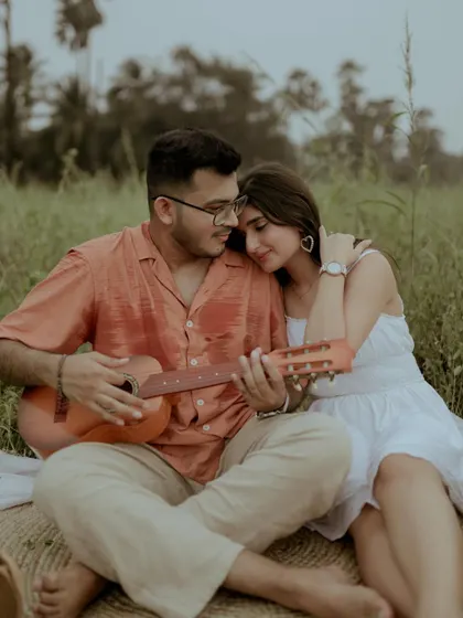 A perfect picnic moment. He plays the guitar for her in a beautiful green field, a simple and incredibly romantic scene for a pre-wedding shoot.