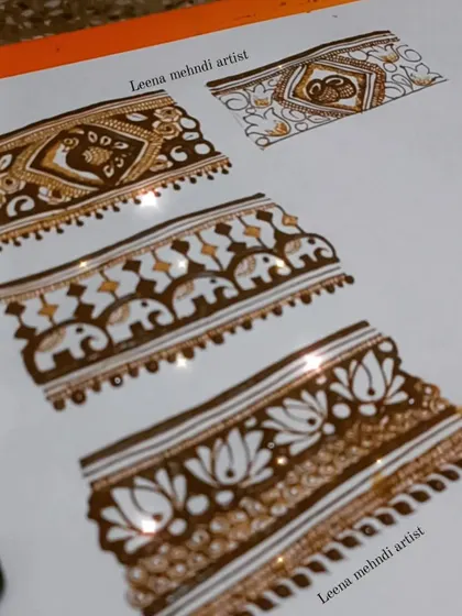 A practice sheet showcasing different styles of intricate bridal borders. These include patterns with peacocks, elephants, and geometric shapes.
