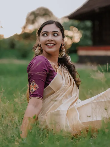 A beautiful candid portrait of the bride sitting in the grass, her smile natural and lovely.