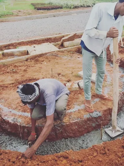 Translating curved lines from a drawing to the physical site is always an exciting moment. Workers carefully construct the foundation for a serpentine path, a key element in this ongoing community park project.