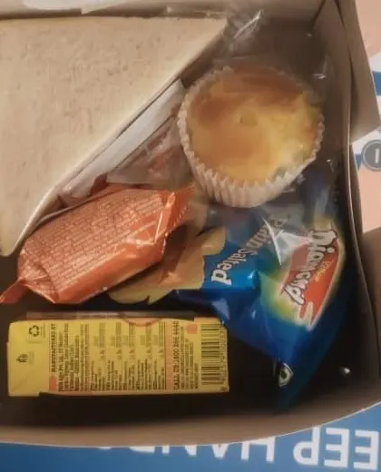 A classic combination for a simple and light snack box. This box includes a triangle sandwich, a muffin, a packet of chips, and a juice box, suitable for morning meetings or school events.