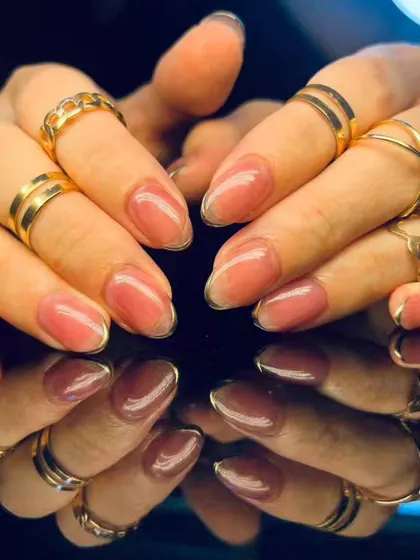 A full view of the elegant shimmery pink and gold outline nails.