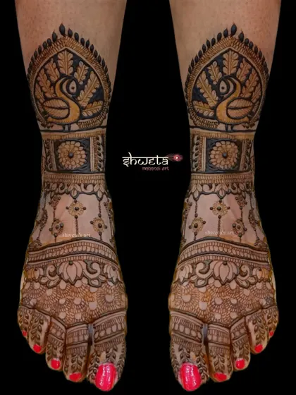 A striking leg design featuring bold peacock motifs. The use of dark-filled areas creates a powerful contrast, making this a standout choice for a bride's feet.