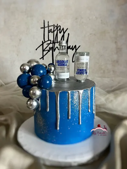 Celebrate in high spirits! A cake for a vodka lover, featuring a vibrant blue design, silver drip, and miniature Absolut bottles.