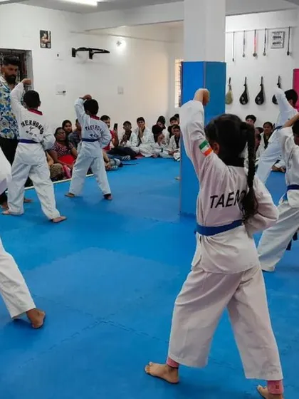 Blue belt students practicing an upper block with a loud kiyap (shout).