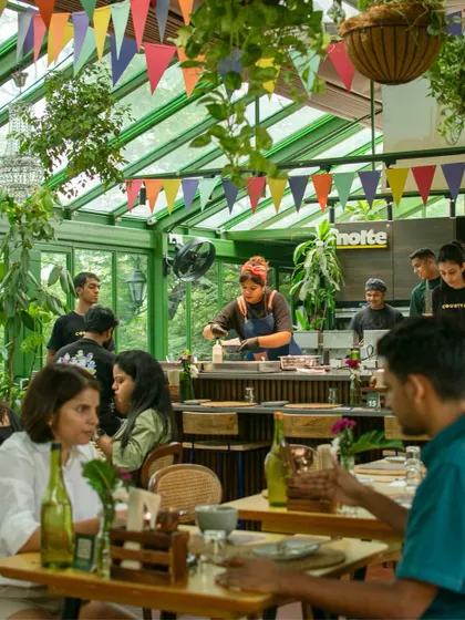 The vibrant, festive atmosphere of our Poee Sandwich Shop. The open kitchen allows guests to be part of the action, watching as chefs prepare their food.