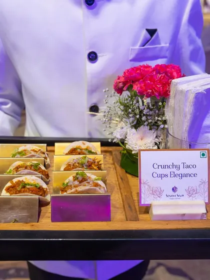 A duplicate of image 22, showcasing our "Crunchy Taco Cups Elegance." The tray is presented by our impeccably dressed staff, highlighting our focus on polished and professional service.