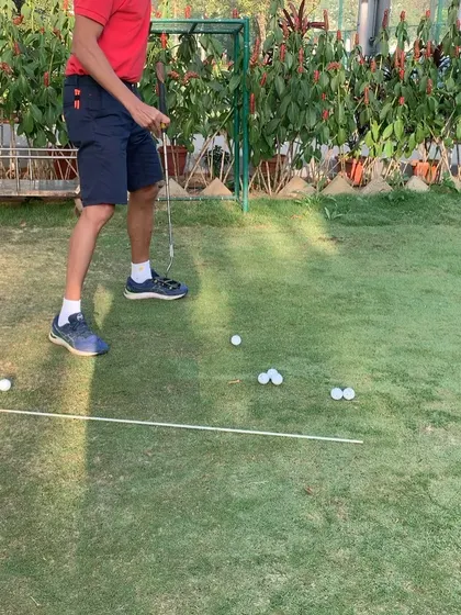 Practicing distance control in putting. This drill helps the student get a feel for how different stroke lengths affect how far the ball rolls on the green.
