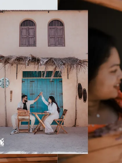 A playful moment captured as a couple high-fives at a cafe table, set against a charming, rustic backdrop.