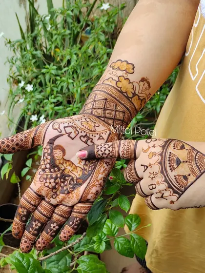 A playful pose showing off a baby shower design. The mehndi features a baby on the moon, angels in the clouds, and the word "BABY" spelled out on the fingers.