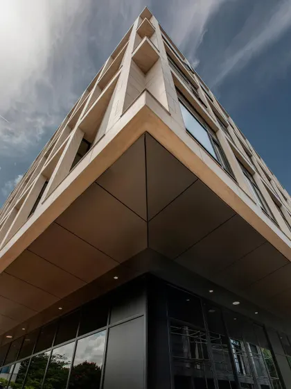 A low-angle view of Stone Boulevard highlights the building's sharp, clean lines and the precise alignment of its marble panels. This perspective emphasizes the structure's monumental quality and our attention to geometric detail.