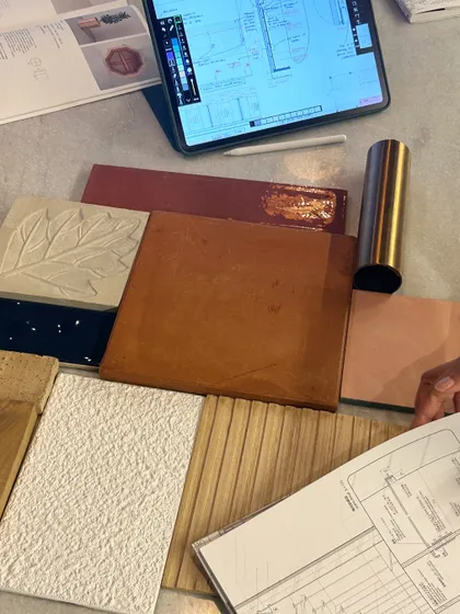 A flat lay of material samples and drawings on our studio table. This is where the magic happens, as we mix and match textures, colors, and finishes to create the perfect palette for a project.