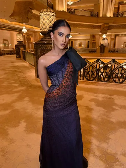 The full view of this stunning one-shoulder gown. The sleek updo and clean makeup ensure the dress remains the hero of the look.