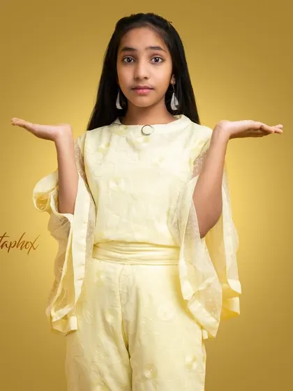 A stylish portrait of a young girl in a fashionable yellow outfit. The warm, gradient background and her confident pose give this image a polished, editorial feel suitable for youth fashion.