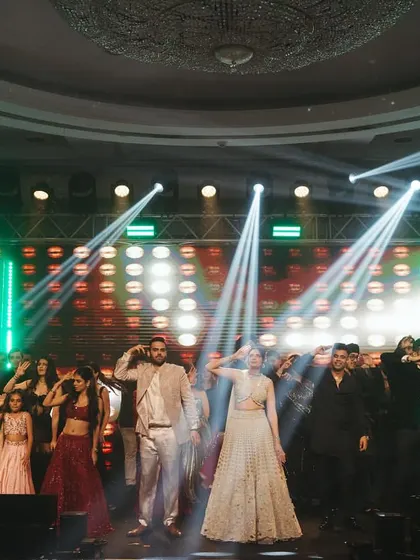 The couple taking a bow with their entire squad after a fantastic performance. The stage lighting and energy are incredible.