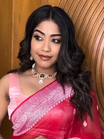 A portrait of the client with her open hairstyle and red saree. This look is perfect for a party or a casual festive occasion.