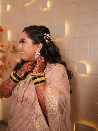 A candid getting-ready shot. Her half-up hairstyle is adorned with a delicate accessory, adding a touch of sparkle to her reception look.