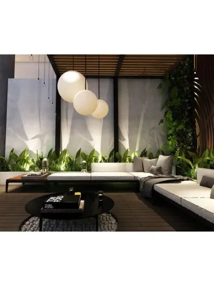 A cozy corner of the terrace lounge, surrounded by a lush green wall and illuminated by modern spherical pendant lights.