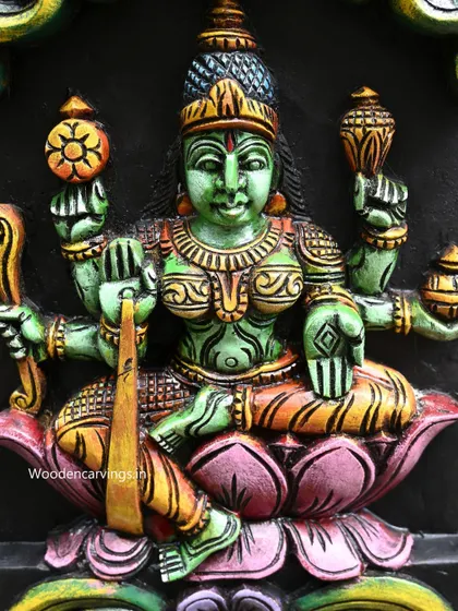 Detail of Dhanya Lakshmi from the vertical Astalakshmi panel, painted in a serene green, holding sheaves of paddy.