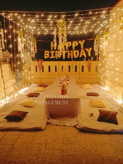 The warm glow from the fairy lights creates a beautiful ambiance, perfect for a memorable birthday evening with friends.