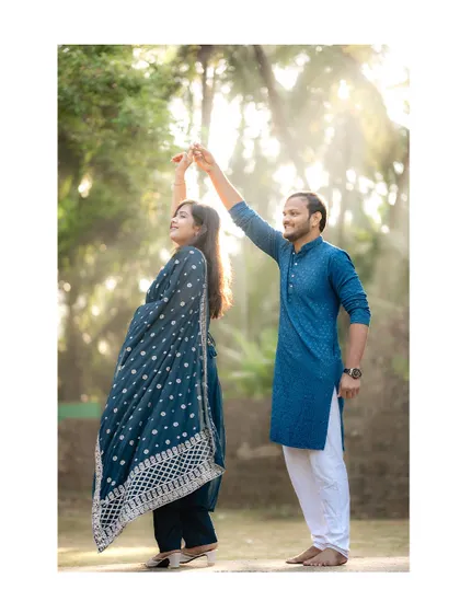 A graceful pre-wedding photo of a couple dancing in a sunlit clearing. The backlighting creates a beautiful, dreamy halo effect, perfect for a romantic shoot.
